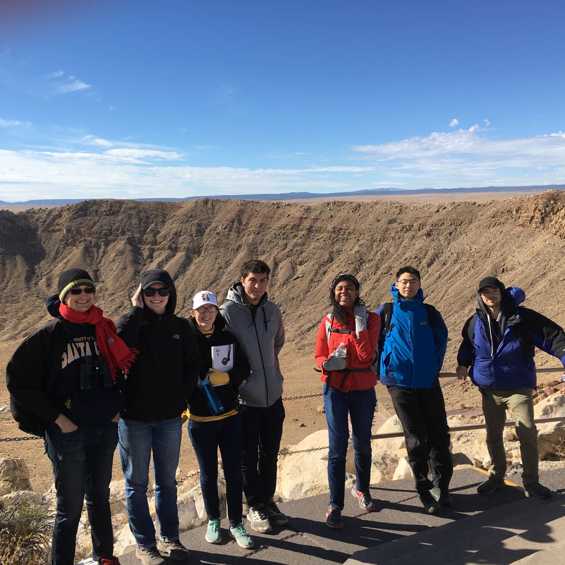 Professors and students standing on the rim of an impact crater in Arizona.
