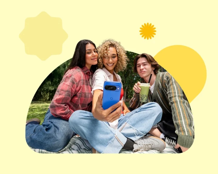 Three friends sitting outside taking a selfie with a Google Pixel 10 in Indigo. Image is surrounded by graphic shapes in shades of yellow.