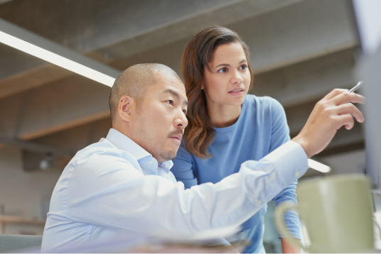 Man and woman pointing at screen