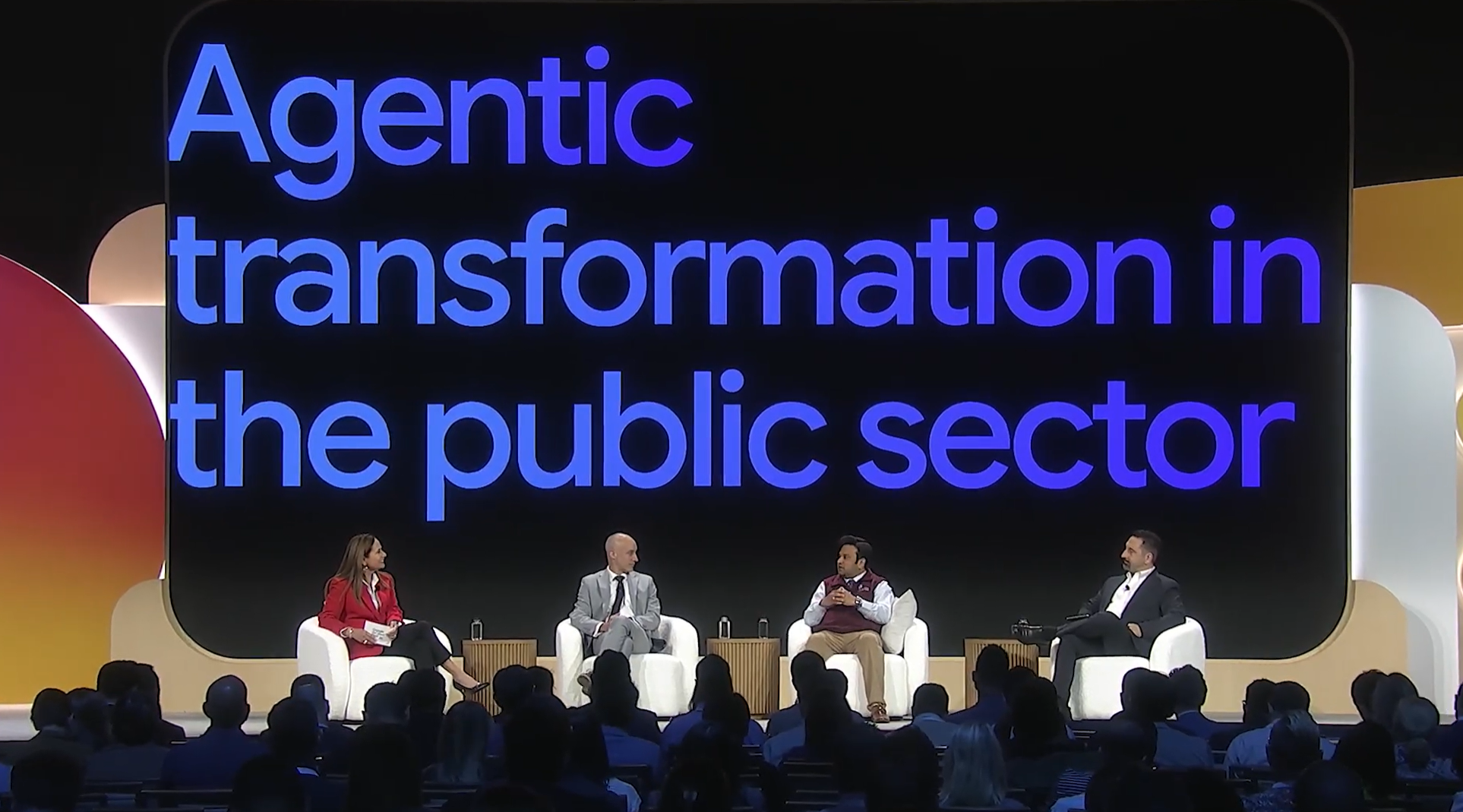 conferencia con cuatro oradores en el escenario con el título "Transformación de agentes en el sector público" de fondo